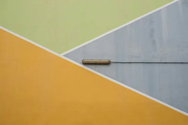 A dark door against a bright yellow painted wall